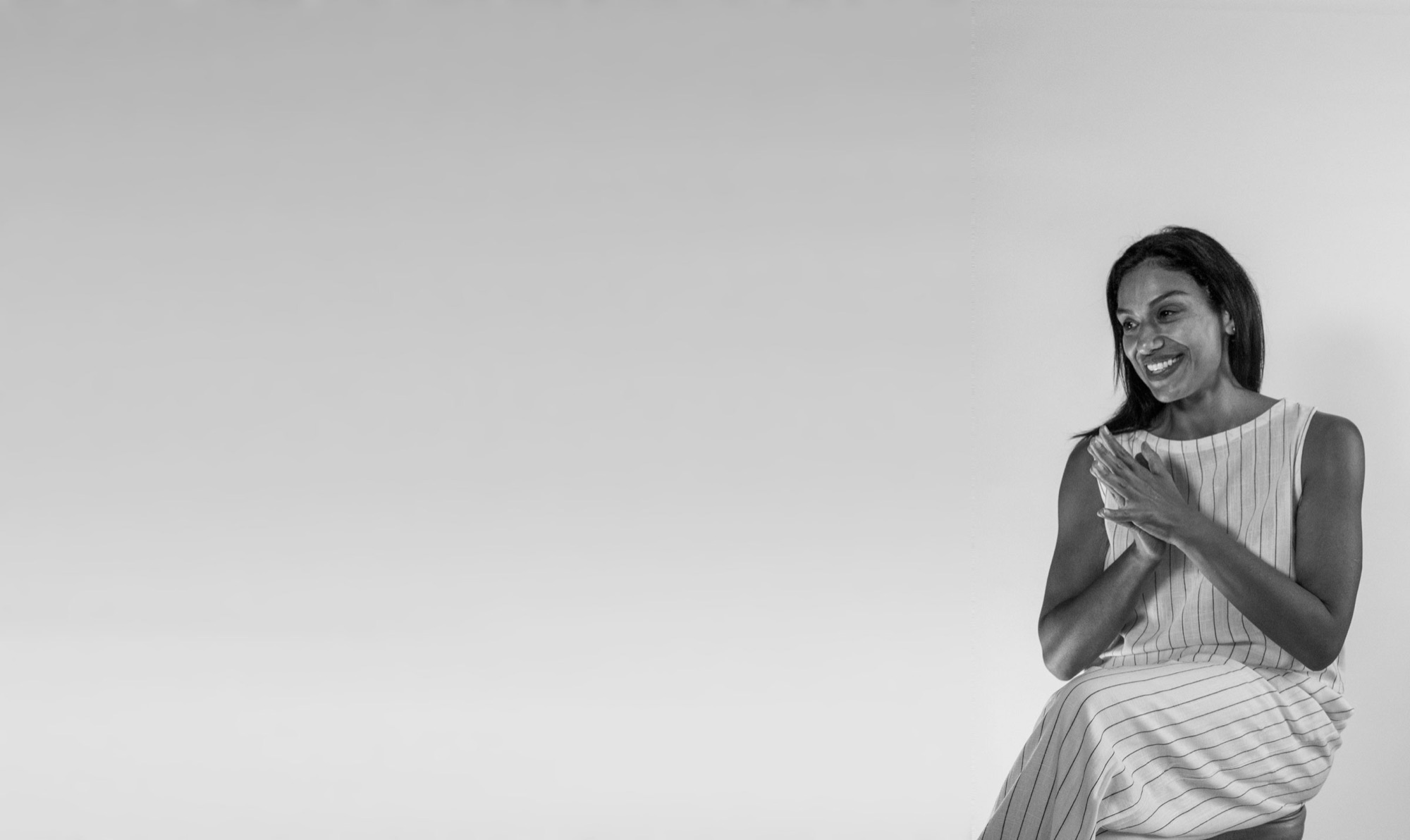 Giselle Kermanioun smiling, seated against a pale studio wall